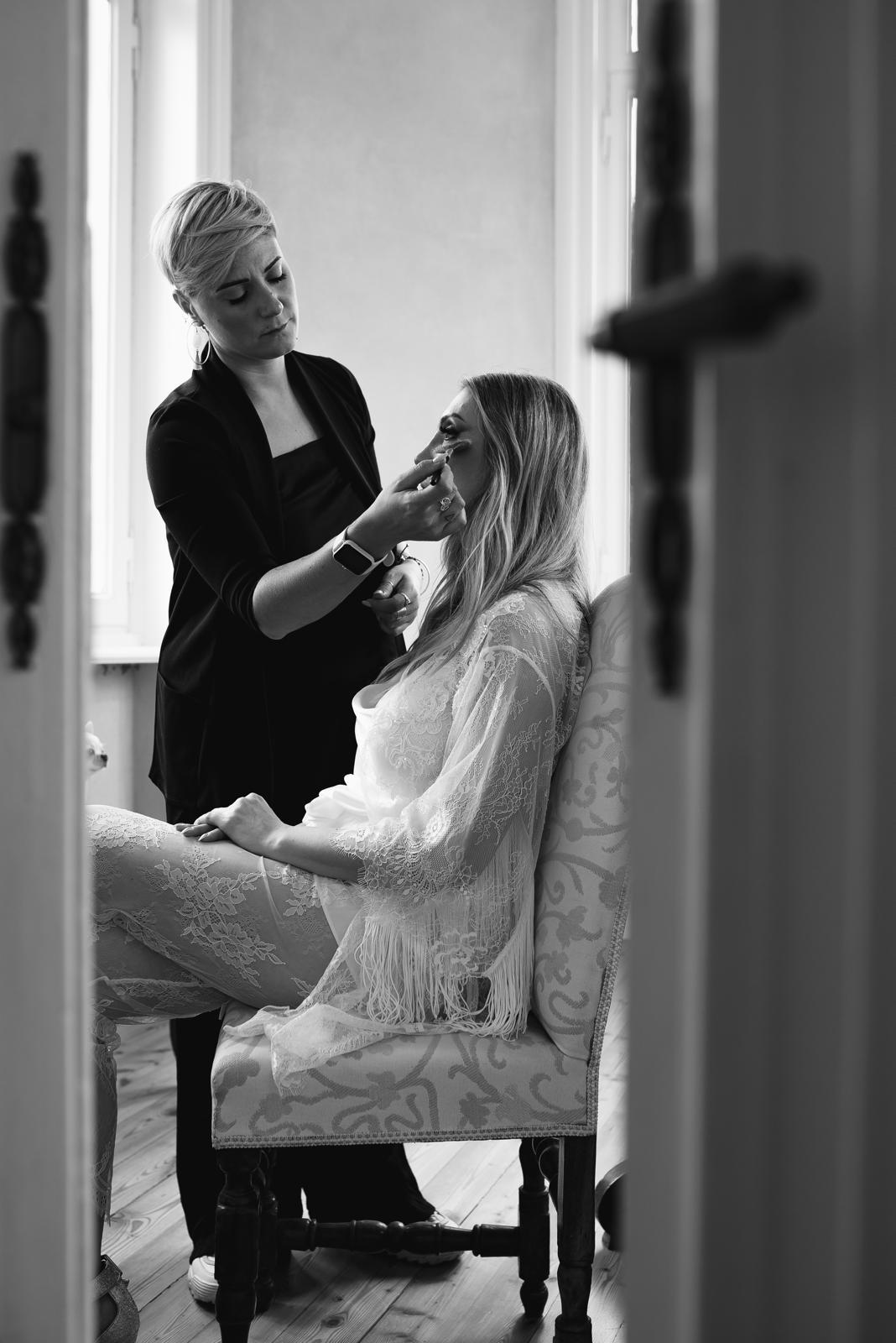 Backstage in bianco e nero: il trucco di una sposa durante la preparazione