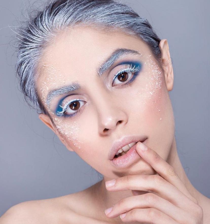 Trucco creativo con sopracciglia argentate, ombretto azzurro e cristalli sugli zigomi