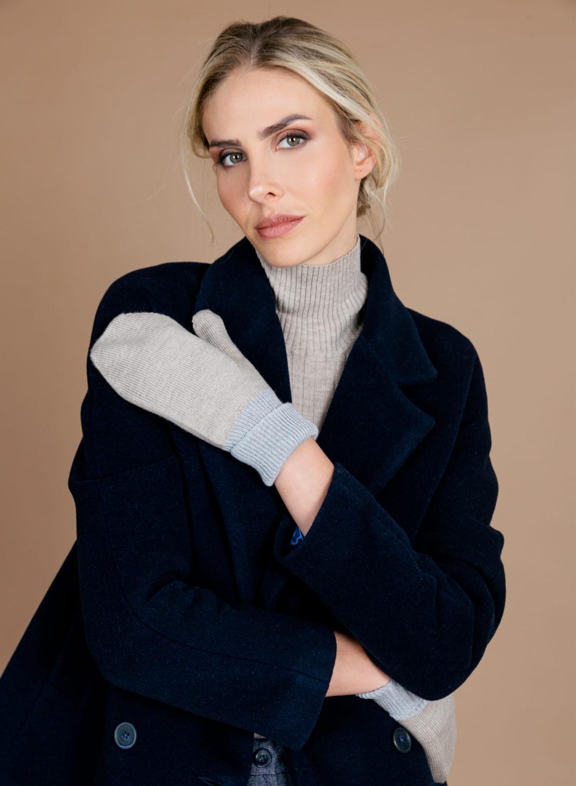 Ritratto in cappotto blu su fondo nocciola, con trucco pulito e definito