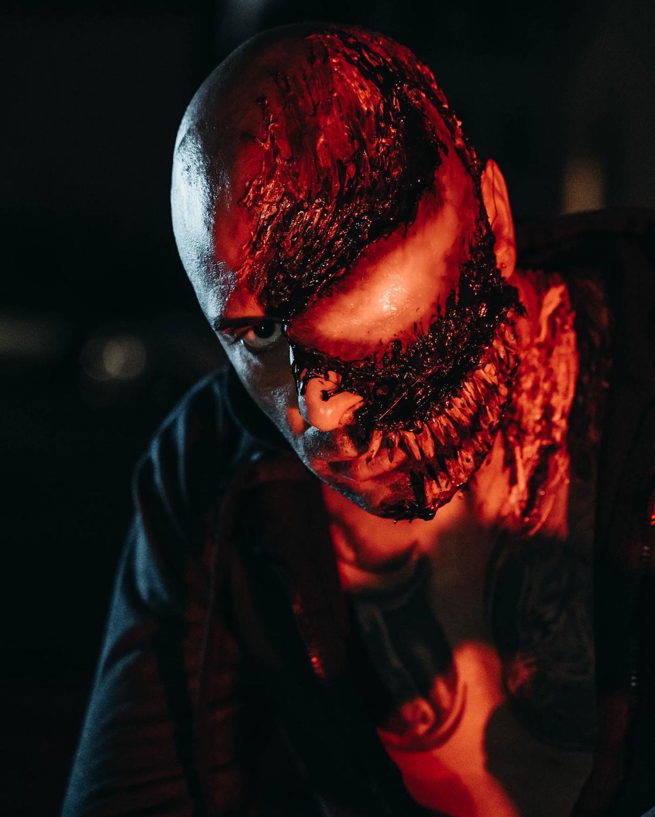 Trucco effetti speciali rosso e nero che trasforma il volto in una creatura