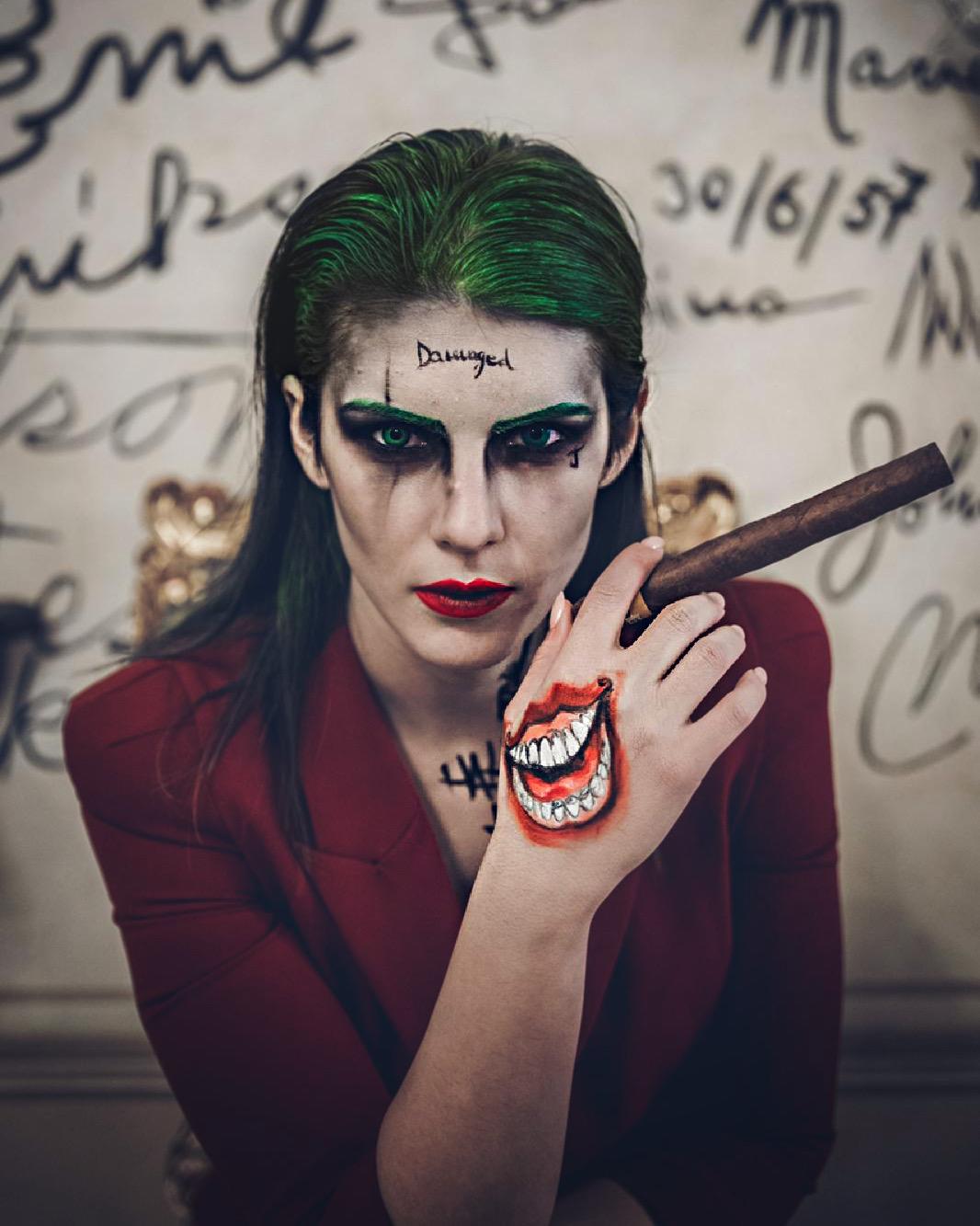 Trucco ispirato al Joker con capelli verdi e un sorriso dipinto sulla mano